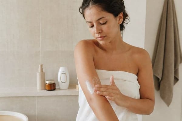 Woman applying Lumimor body lotion after her shower