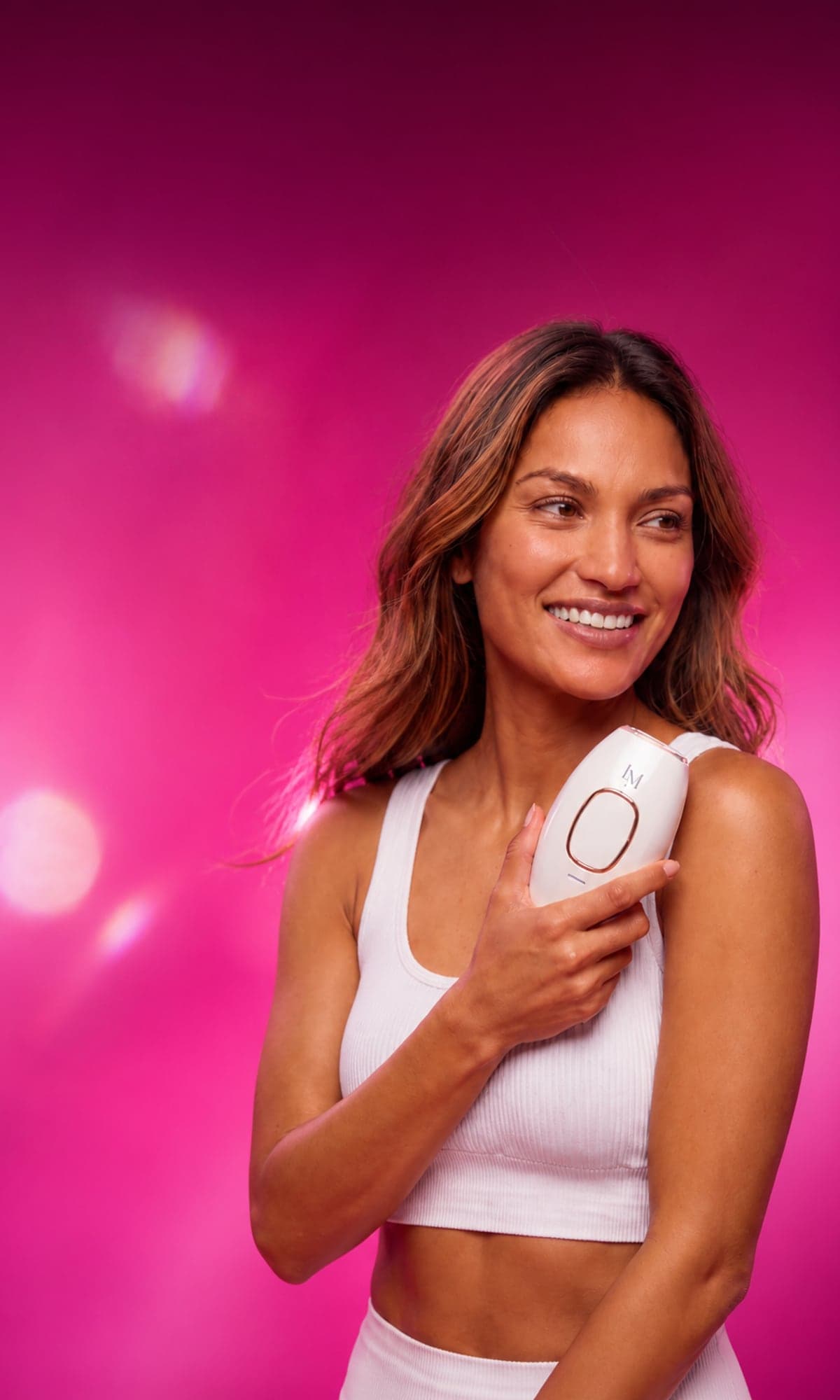 Woman smiling while holding a white Lumimor IPL device